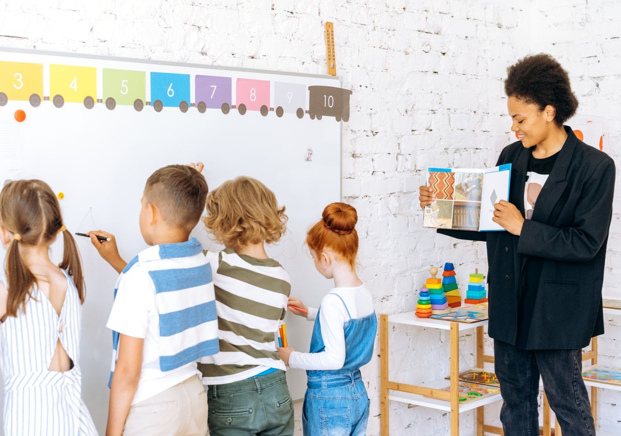Une enseignante accompagne des élèves en classe